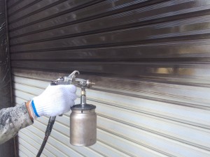 シャッターに塗料を吹き付け中