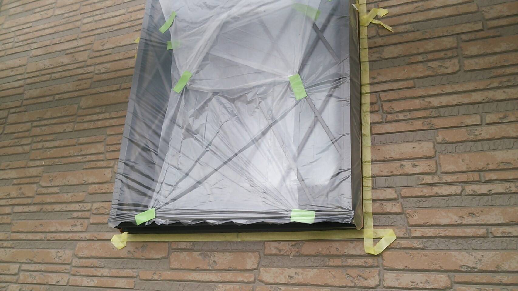 外壁の養生作業中（コーキング用の養生）