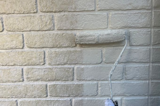 レンガ調サイディング外壁へローラーを用いて中塗り塗装を実施