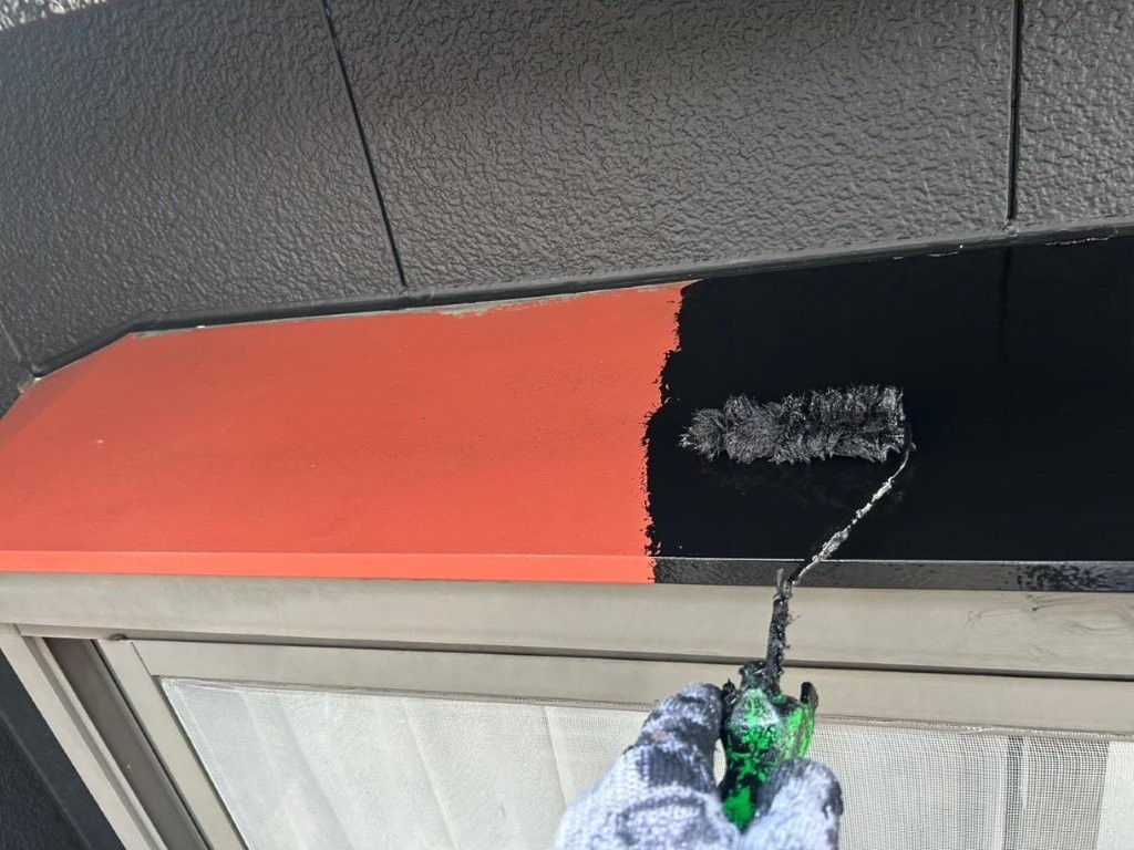 シャッターボックス鉄部の中塗り塗装中 錆止め塗装後に主材塗料をローラーで塗布している様子